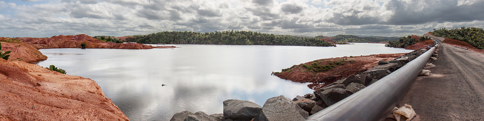 A mine tailings reservoir in Africa, receiving slurry through a pipeline from an ore processing plant.