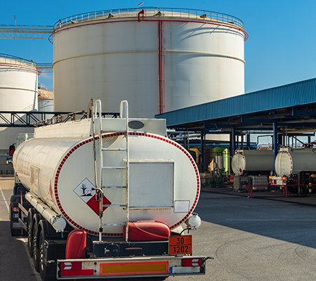 A fuel tanker truck waiting to load at a loading dock.