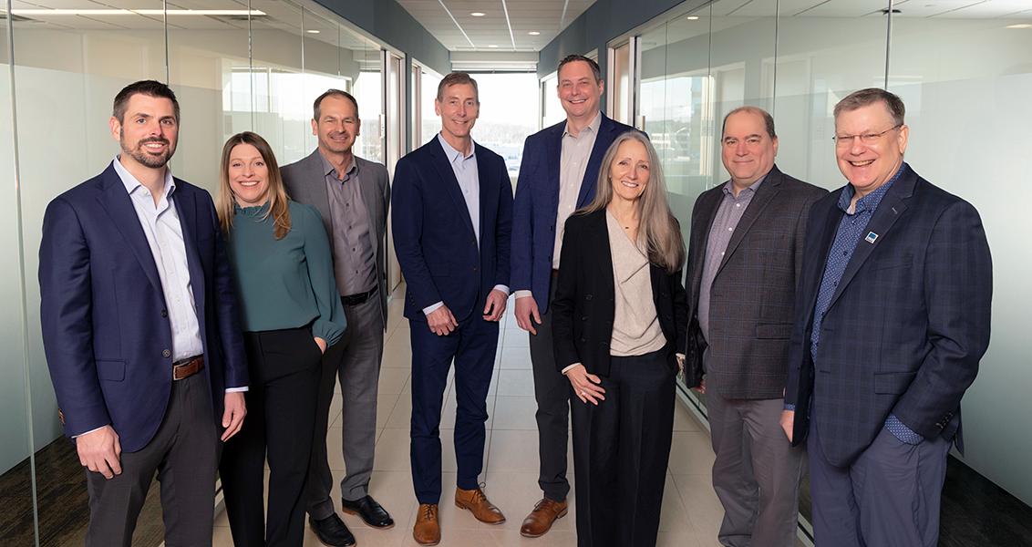 A group photo of the eight members of Barr's management team.