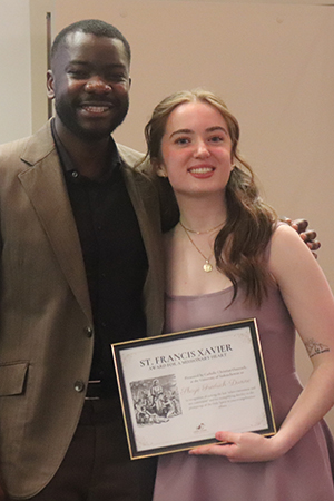Shaye is holding an award recognizing her commitment to volunteerism, leadership, and making a positive impact in her community.