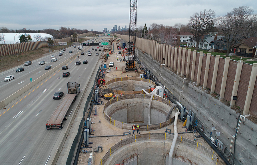 Drone view of the I-35W underground stormwater storage facility during construction, with a view of downtown Minneapolis in the background.