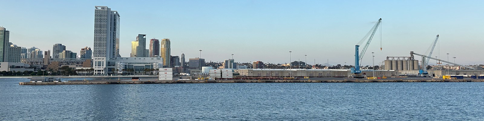 A marine port terminal against a San Diego downtown skyline at sunset.