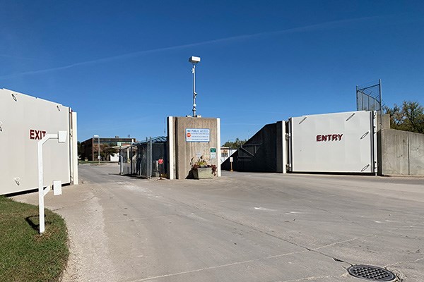 An open floodgate serving as the entrance to a water treatment plant facility on a clear sunny day.