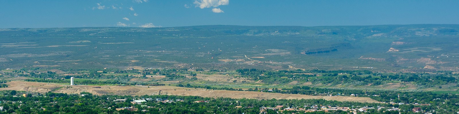 A landscape view of Montrose, Colorado, on a sunny day, with mountains in the background.